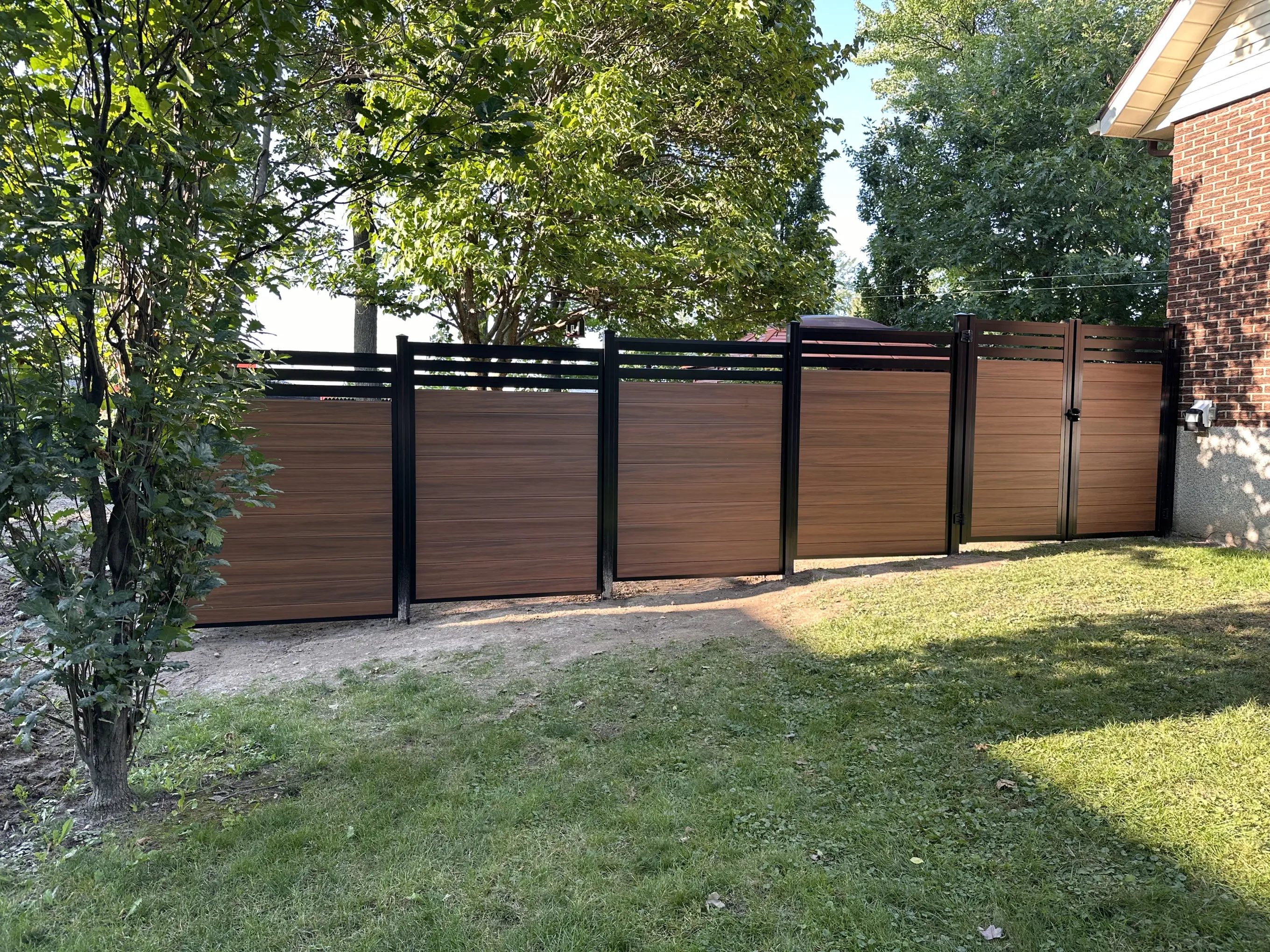 Clôture composite brune avec poteaux noirs
