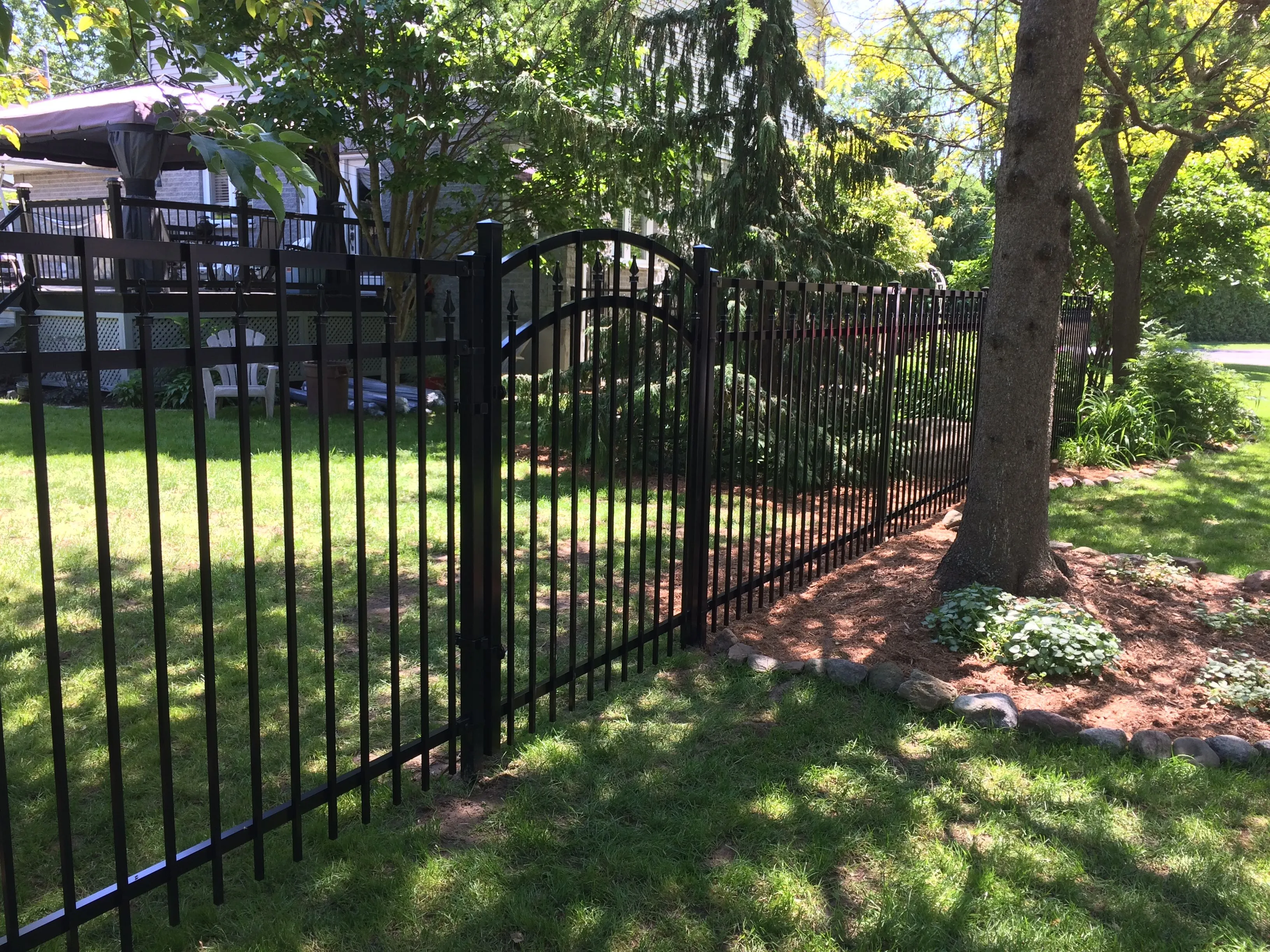 Porte arquée de clôture ornementale en aluminium avec arbres matures